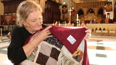 Woman in a catholic church holds small blanket