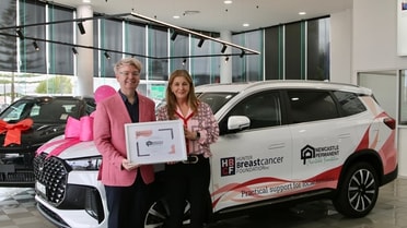 Hunter Breast Cancer Foundation (L-R) Josh Lawler Fundraising, Events & Marketing Coordinator HBCF, Louise Ross HBCF General Manager holding award in front of new car