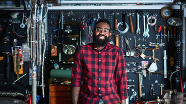 Man standing in workshop in front of tools