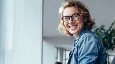 Woman in glasses with a short blonde bob smiles
