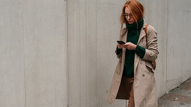 Woman walking outside looking at her phone 