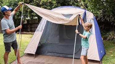 dad and son setting up backyard camping 