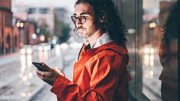 Man outside in the rain on his phone 