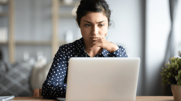 Woman looking at laptop confused
