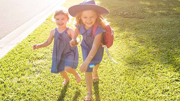 girls running in school uniforms holding hands smiling