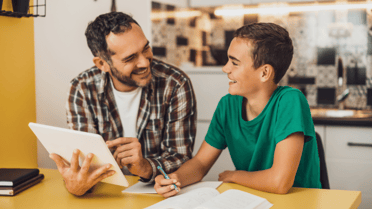 Parent holding a tablet smiling at kid 