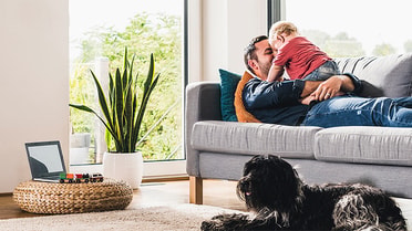 Father hugging son in couch 