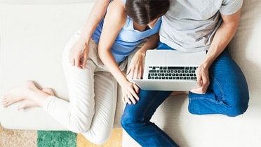 Couple on couch with laptop