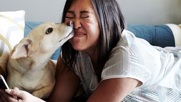 person with dog licking face