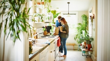 couple in kitchen with pot plants all around