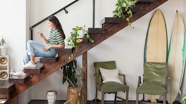 Interior of home with girl sitting on steps using her phone