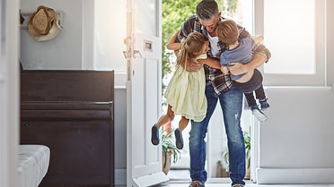 Dad picking up kids walking into new home