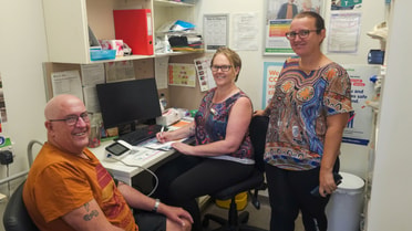 Client and Health workers smile in an office room