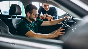 Young man in front seat of new car