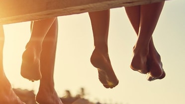 Foot hanging from wooden deck 