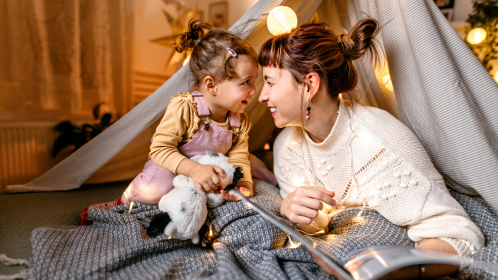 Woman and child in TeePee smiling at one another