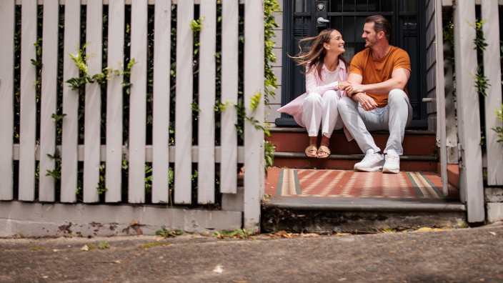 Woman and man sitting on front step of their home