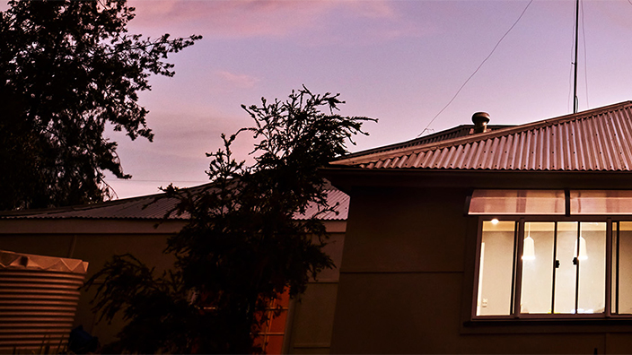 purple and pink sunset behind house